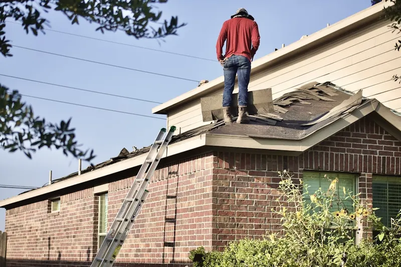 Professional roofer working on a residential roof in Aluta